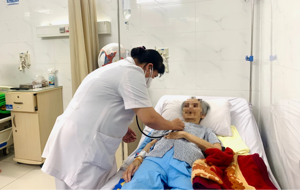 Bác sĩ Trần Thị Vân Anh thăm khám cho bệnh nhân 80 tuổi mắc viêm não do virus herpes. Ảnh: THẢO PHƯƠNG