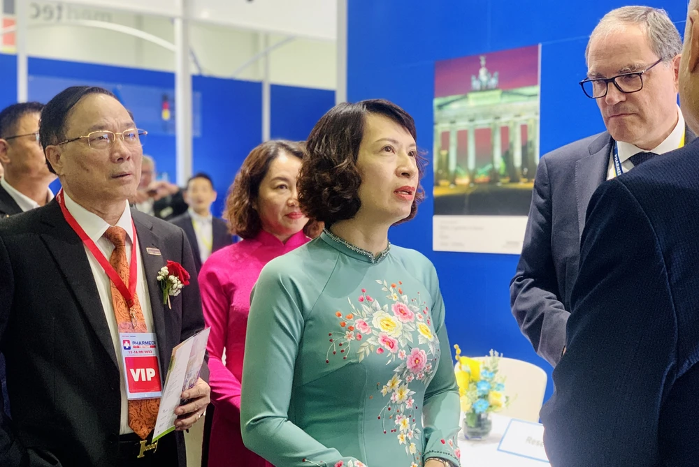 Bà Nguyễn Thị Liên Hương, Thứ trưởng Bộ Y tế, trao đổi với các chủ gian hàng thiết bị y tế trong triển lãm Y tế quốc tế 2023. Ảnh: THẢO PHƯƠNG