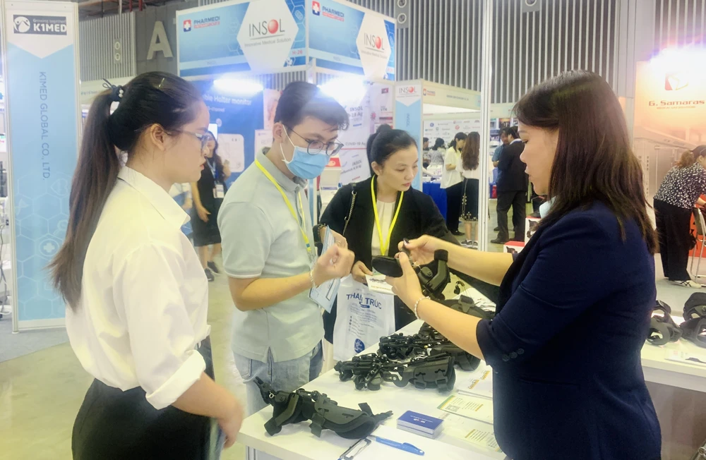 Khách tìm hiểu về thiết bị hỗ trợ phục hồi chức năng. Ảnh: THẢO PHƯƠNG