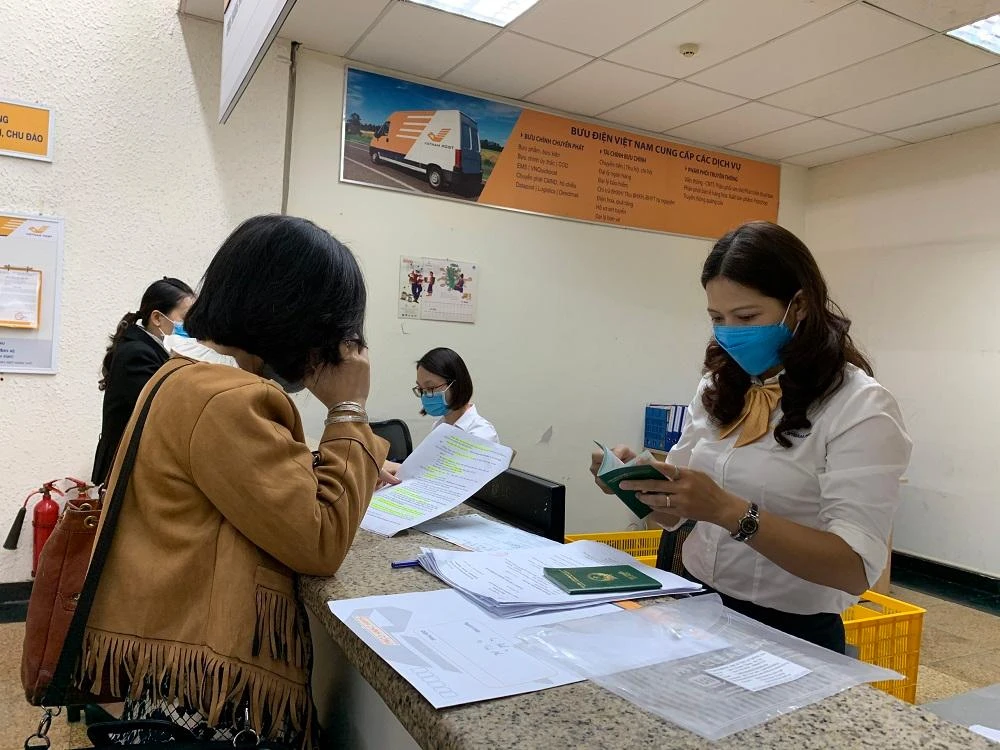 Khách hàng nộp hồ sơ làm thủ tục chứng nhận lãnh sự tại Bưu điện Hà Nội. Ảnh: VNPost