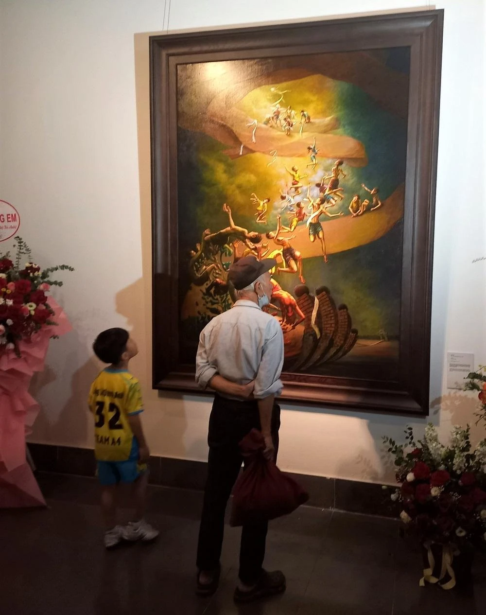 Hai thế hệ cùng xem tranh tại lễ khai mạc. Ảnh: VIẾT THỊNH