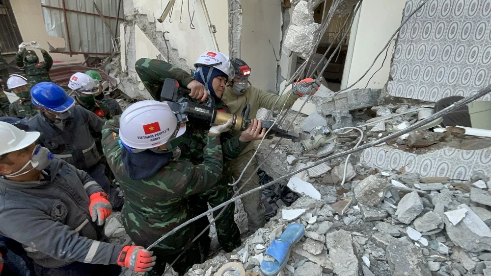 Đội Công binh cứu sập sử dụng kìm thủy lực cắt sắt để mở rộng lối vào, nơi được xác định có 2 nạn nhân thiệt mạng. Ảnh: VĂN HIẾU