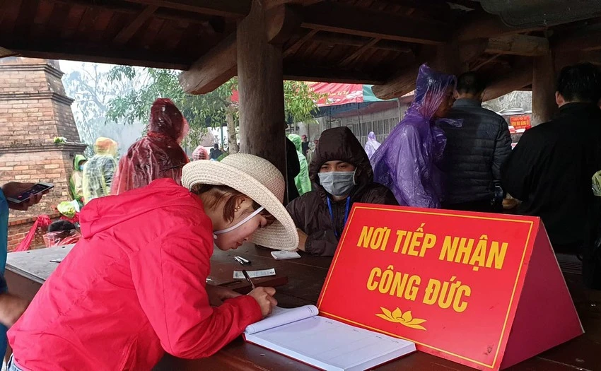 Người dân ghi công đức tại Yên Tử. Ảnh: ĐỖ HOÀNG.