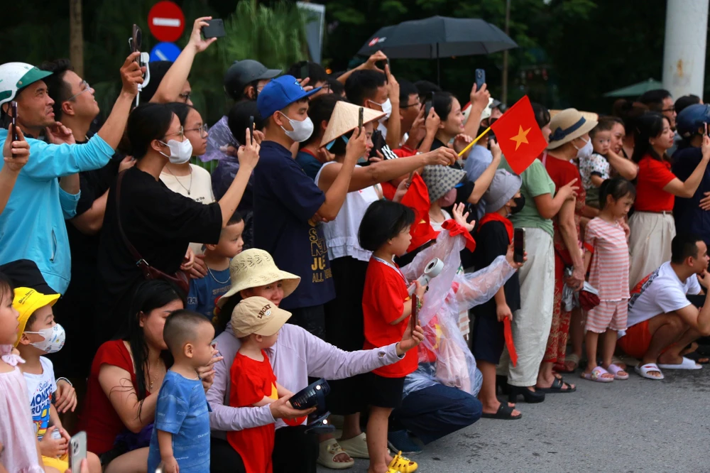 Người dân chào đón các khối diễu binh, diễu hành đi qua. Ảnh: THUÝ HẰNG.