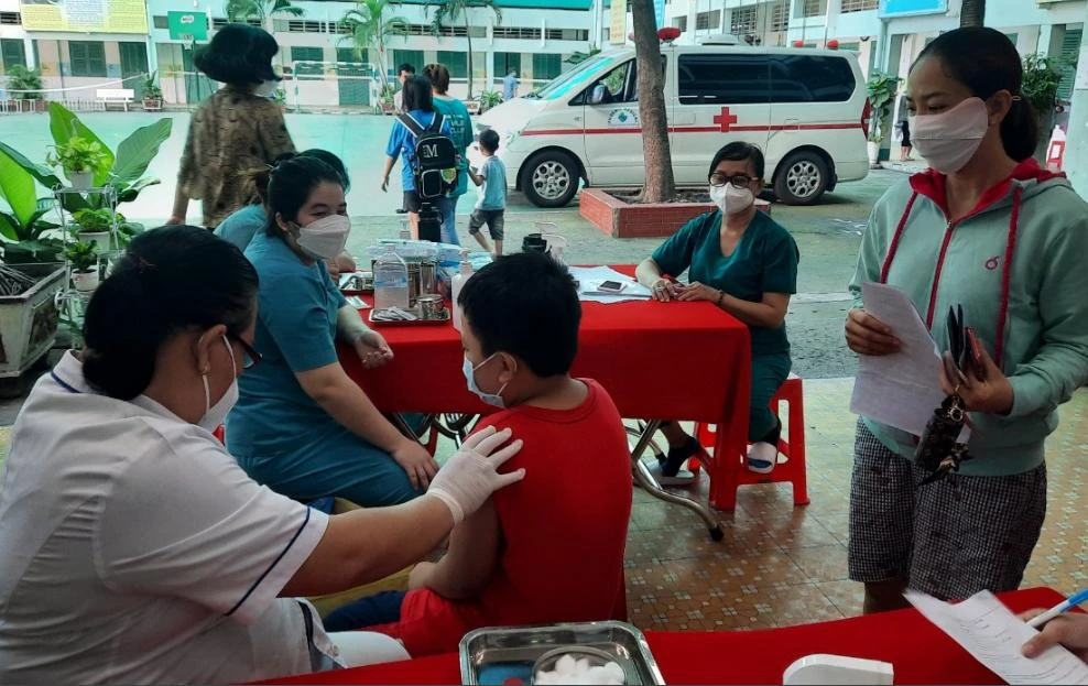 Học sinh quận 11, TP.HCM được xe lưu động tới trường tiêm vaccine ngừa COVID-19. Ảnh: TRẦN NGỌC