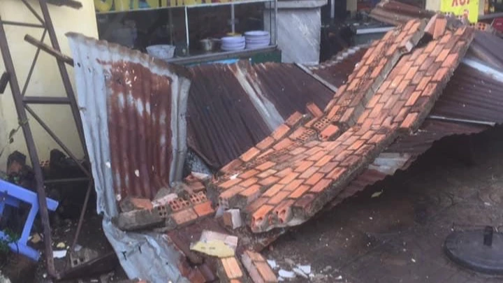 Bức tường của ki ốt sập đè hư hỏng xe máy của người dân. Ảnh: VT