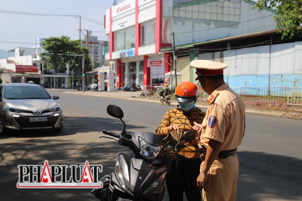 Một trường hợp đi xe máy vượt đèn đỏ bị xử lý. Ảnh: VÕ TÙNG