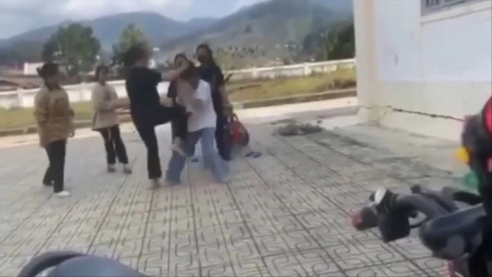 2 nữ sinh đánh nhau, nhiều bạn xung quanh đứng nhìn và quay phim
