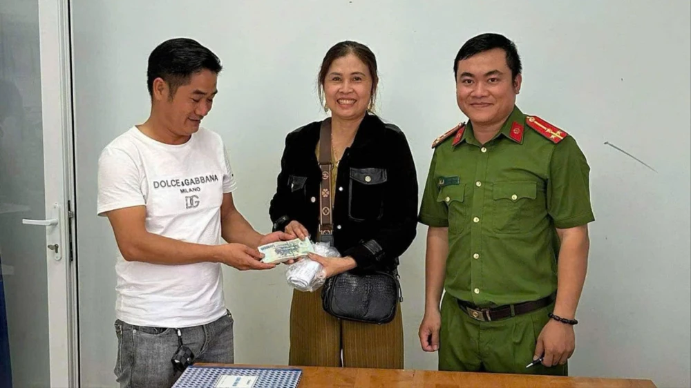 Đại úy Lại Đức Thiện (áo trắng) đại diện cho 3 cán bộ Trại giam Đại Bình phối hợp với Công an xã Lộc Nam trao trả lại tiền cho bà Nhiệm. Ảnh: VT