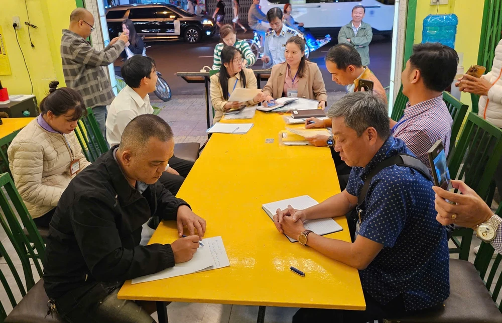 Chủ nhà hàng Aroma Beach (bìa trái) làm việc với đoàn kiểm tra liên ngành TP Nha Trang. Ảnh: XH