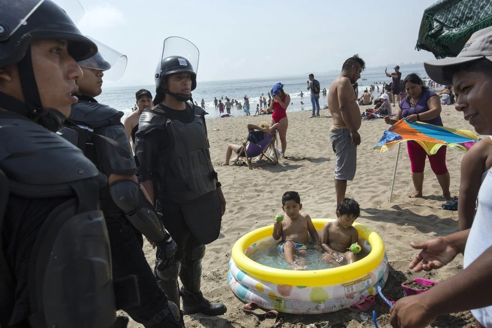 Những nhân viên an ninh ngày 24-3 chỉ còn đi tuần tra trên một bãi biển không một bóng người. Ảnh: AP 1