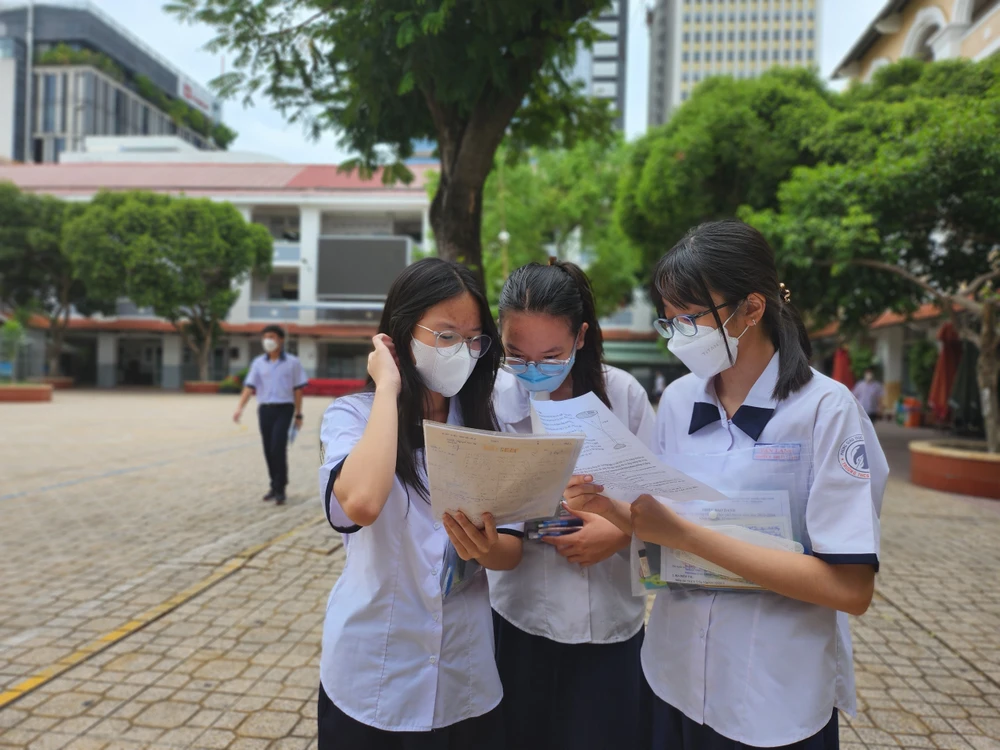 Các thí sinh trao đổi kết quả sau khi thi xong môn Toán. Ảnh: NGUYỄN QUYÊN