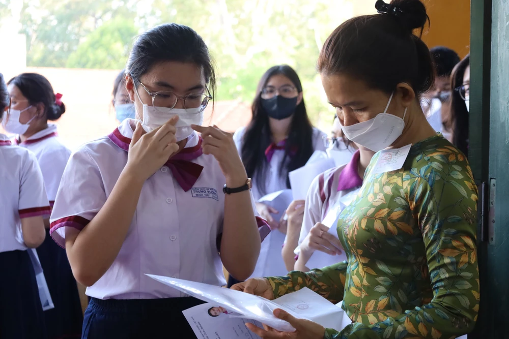 Cán bộ coi thi kiểm tra trước khi vào phòng thi. Ảnh: TRẦN MINH