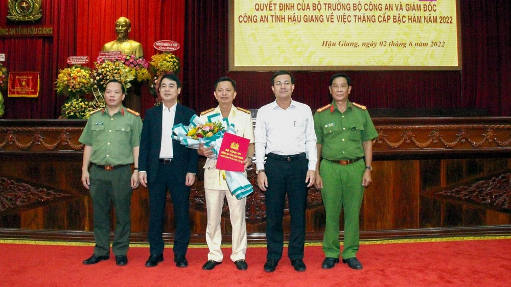 Đại tá Huỳnh Việt Hòa (đứng giữa) nhận Quyết định thăng cấp bậc hàm của Bộ trưởng Bộ Công an. Ảnh: Công an Hậu Giang