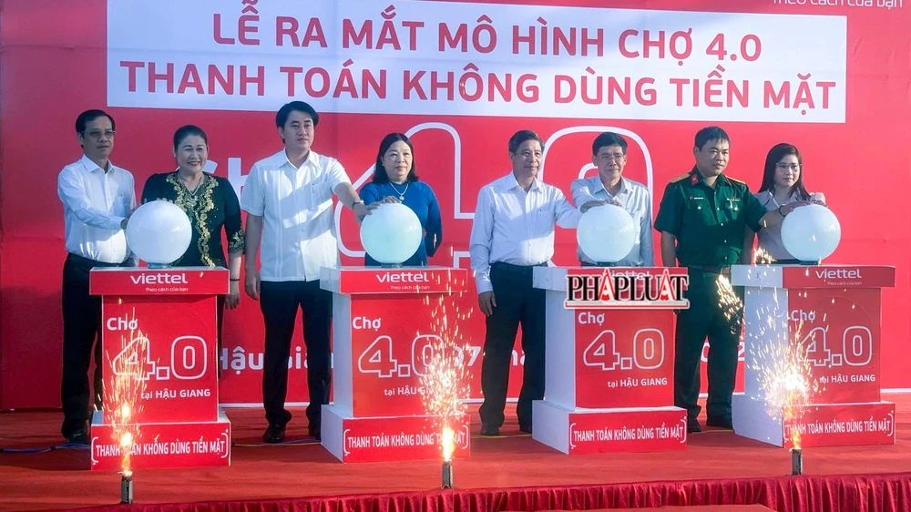Các đại biểu thực hiện nghi thức ra mắt mô hình Chợ 4.0 thanh toán không dùng tiền mặt tại chợ Vị Thanh (TP Vị Thanh). Ảnh: TP