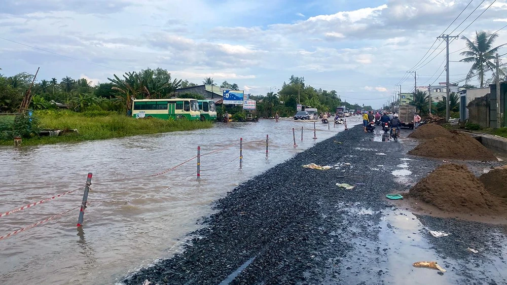 Quốc lộ 1 đoạn từ TP Ngã Bảy (tỉnh Hậu Giang) đến huyện Châu Thành (tỉnh Sóc Trăng) có nhiều đoạn ngập sâu, cạnh đó đang có công trình nên rất khó khăn cho lưu thông. Ảnh: PHẠM TRINH