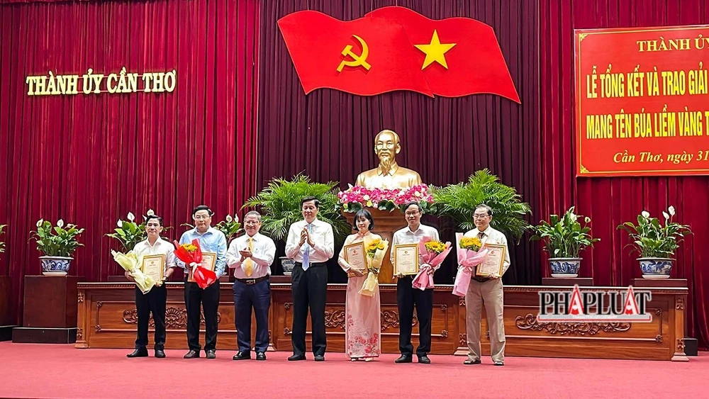 Ông Phạm Văn Hiểu (thứ tư từ phải sang), Phó Bí thư Thường trực Thành ủy và ông Trần Việt Trường (thứ ba từ trái sang) trao giải A cho năm tác giả, nhóm tác giả. Ảnh: CHÂU ANH