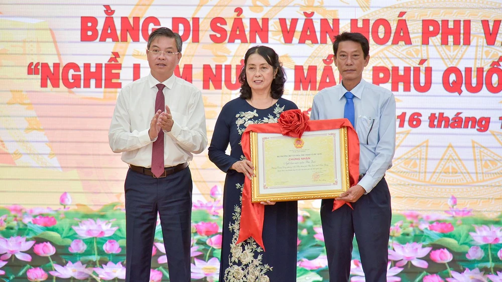 Ông Nguyễn Lưu Trung (bìa trái), Phó Chủ tịch UBND tỉnh Kiên Giang trao bằng công nhận di sản văn hóa phi vật thể cho UBND TP Phú Quốc và Hội nước mắm. Ảnh; TUẤN THY