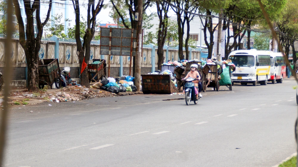 Không chỉ điểm tập kết rác tại cầu Hưng Lợi, theo ghi nhận các điểm khác như trước Bệnh viện Y học cổ truyền, phía trước Công ty cấp thoát nước Cần Thơ đều xảy ra tình trạng lấn chiếm lòng đường tương tự. (Trong ảnh: Bãi tập kết rác phía trước Bệnh viện Y học cổ truyền).