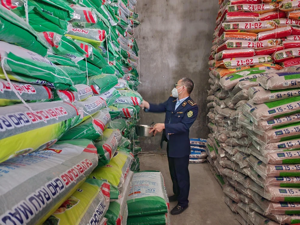 Lực lượng quản lý thị trường lấy mẫu phân bón để kiểm nghiệm chất lượng sản phẩm so với chỉ tiêu công bố trên bao bì sản phẩm. Ảnh: DMS