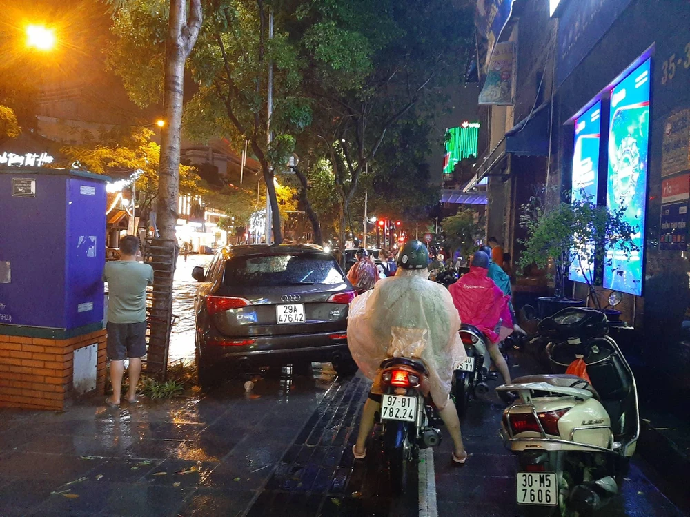 Nhiều người dân phải đi lên vỉa hè, không dám đi qua các đoạn ngập vì sợ xe chết máy. Ảnh: NGUYỄN HẠNH