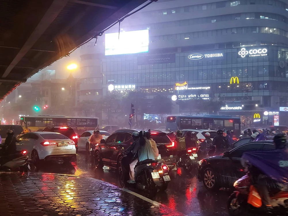 Mưa lớn xối xả diễn ra đúng giờ tan tầm khiến người dân tham gia giao thông rất khó khăn. Ảnh: MINH PHƯƠNG