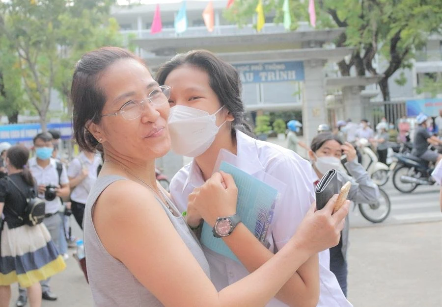 Một học sinh ôm chặt người thân trước khi vào điểm thi. Ảnh: T.AN