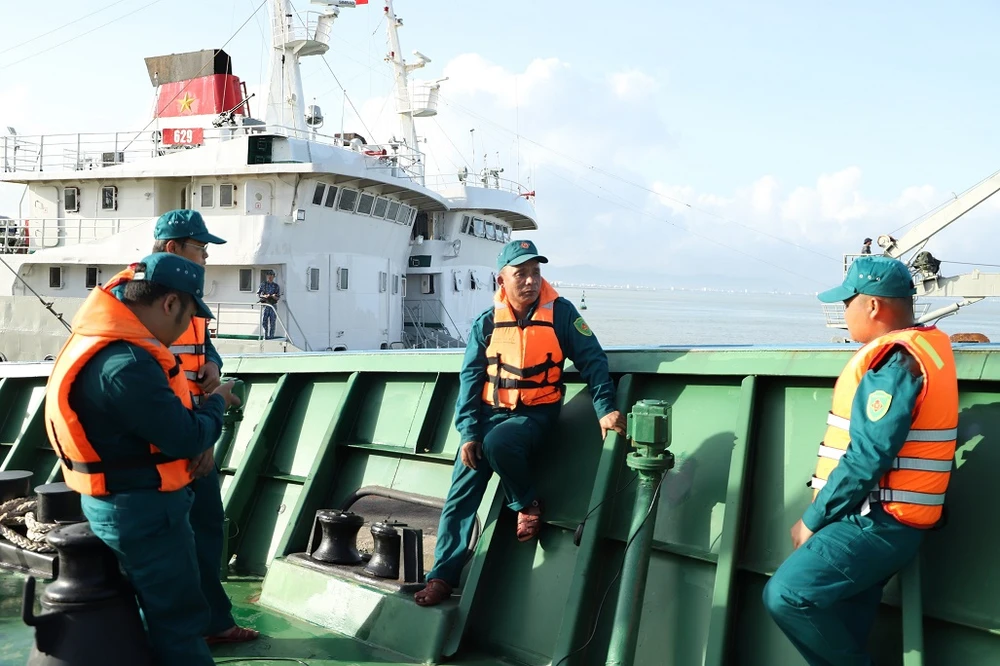 Anh Đinh Công Vương (đứng giữa) đang chia sẻ những kinh nghiệm sóng gió với anh em trên tàu ĐNa 91218TS. Ảnh: HOÀNG DIỆU