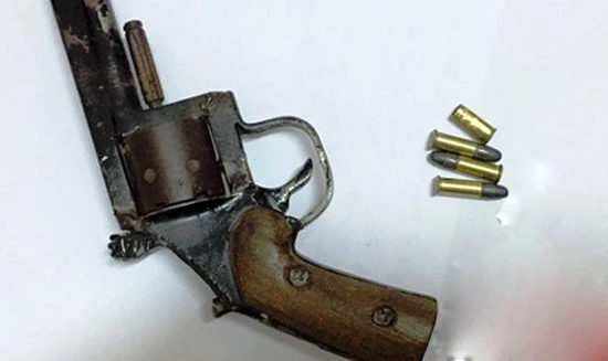 Khẩu súng và đạn bị thu giữ.