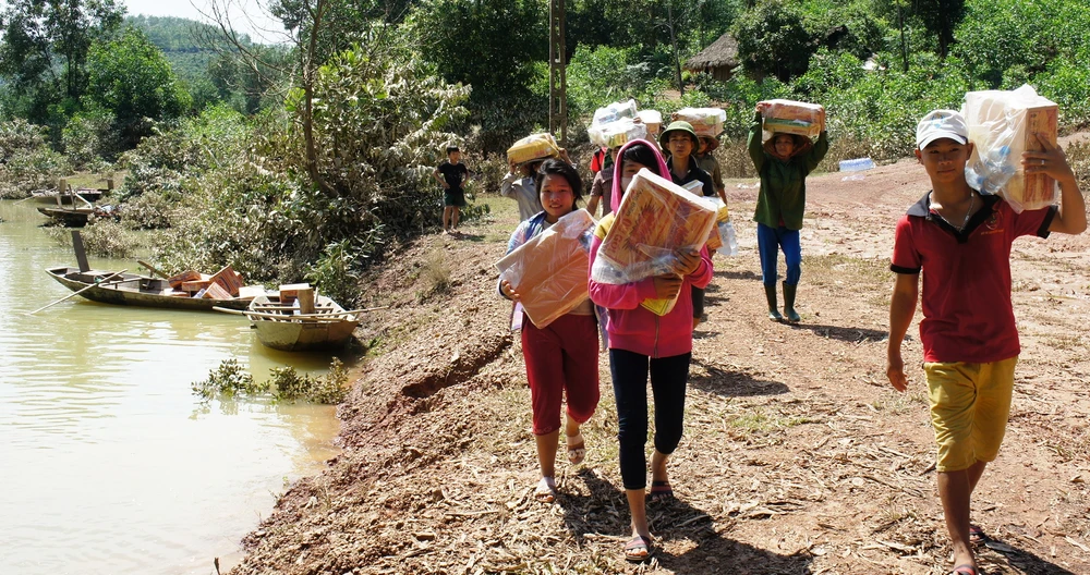 Người dân xã Phương Mỹ (huyện Hương Khê, Hà Tĩnh) đang bị lũ chia cắt phải đi đò rồi lội bộ nhiều km ra gần đường mòn Hồ Chí Minh nhận mì tôm và lương khô. Ảnh: Đ.LAM