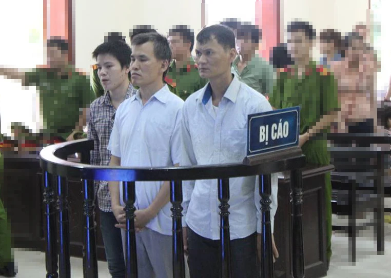 a bị cáo Hùng, Tám và Toản đứng trước vành móng ngựa tại phiên tòa sơ thẩm.