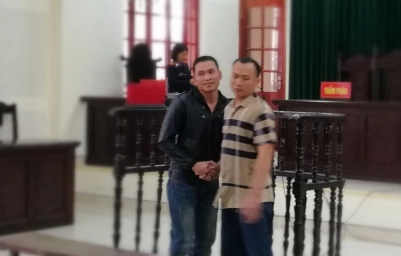 Hai bị cáo bắt tay vui mừng vì cùng được giảm án