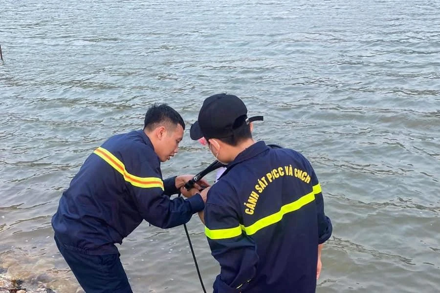 Cảnh sát cứu nạn và cứu hộ xuống đập nước lặn, tìm vớt thi thể các em.