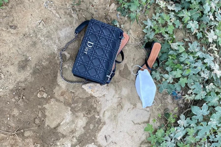 Chiếc túi và đôi dép của nạn nhân để lại trên bờ sông Hiếu. Ảnh: CA.