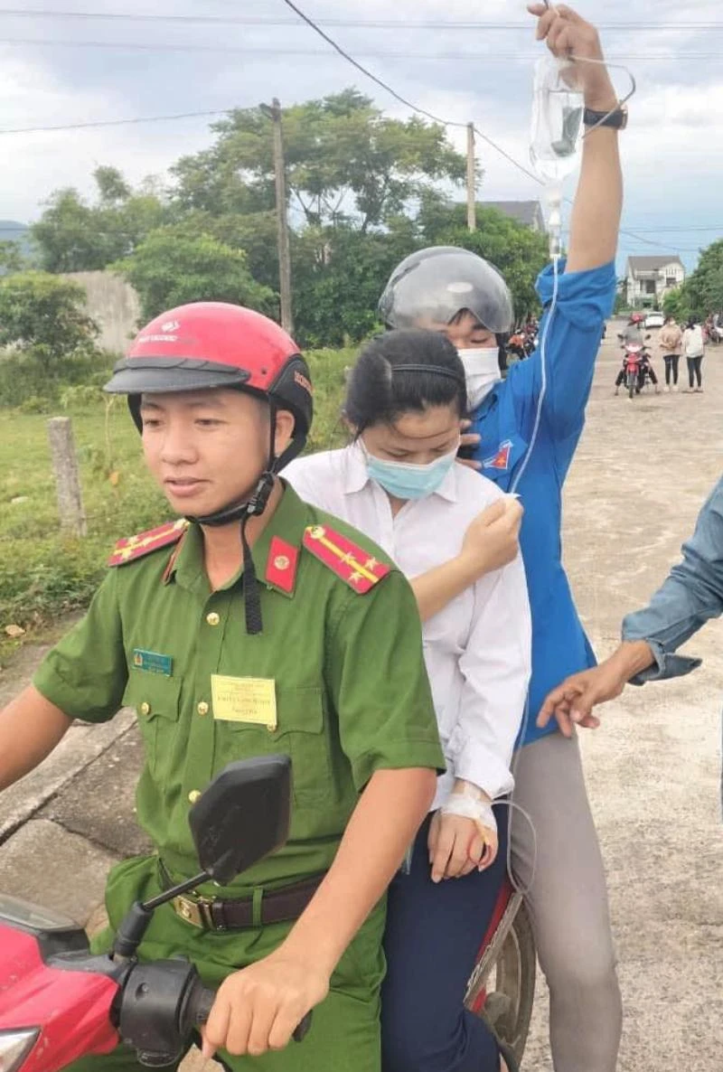 Lực lượng Công an xã Kỳ Thị và thanh niên tình nguyện đưa thí sinh Lâm Hồng Nhung đến điểm thi Trường THPT Nguyễn Thị Bích Châu. Ảnh: KAQT.
