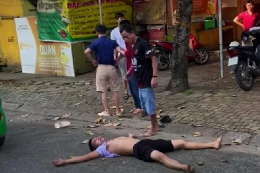 Nam thanh niên nằm bất động trên đường Hà Huy Tập (TP Vinh) nhưng vẫn bị người mặc áo đen tấn công.