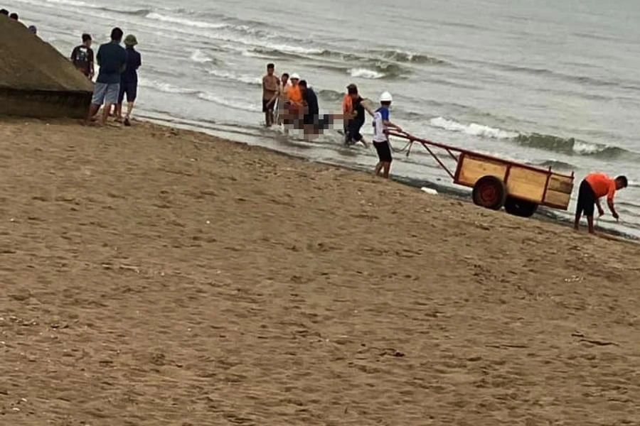 Lực lượng tìm kiếm cứu nạn đưa thi thể nạn nhân lên bờ biển.