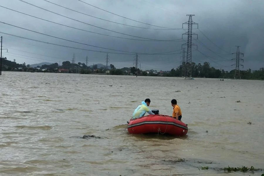 Cảnh sát tìm kiếm người dân mất tích trên cánh đồng nước lũ.