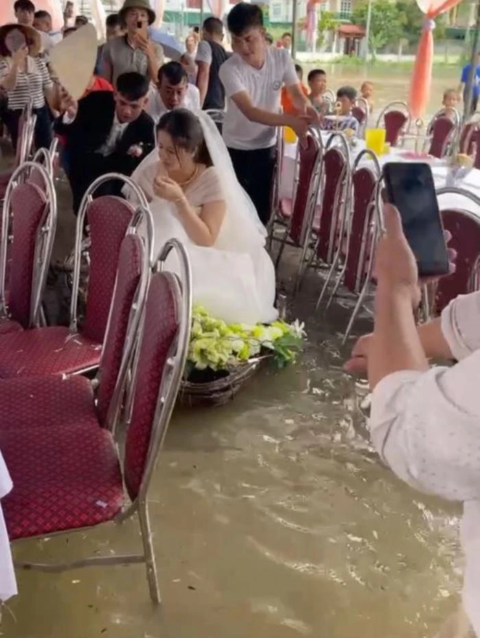 Chú rể đẩy chiếc thuyền chở cô dâu trong rạp cưới tiến lên hôn trường.