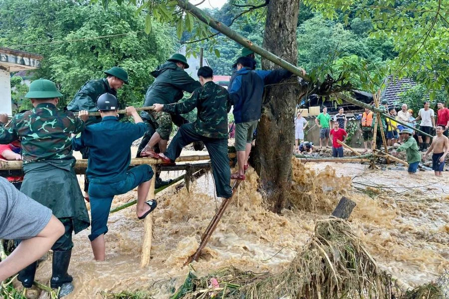 Bộ đội Biên phòng Nghệ An và lực lượng chức năng cố gắng vượt qua dòng lũ để vào với người dân xã Tà Cạ.