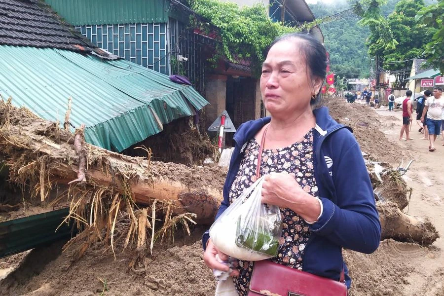 Bà Vang Thị Bình (63 tuổi) trở về với một ít thức ăn trên tay, đứng bật khóc, nói: "Tôi chẳng còn gì nữa, nhà cửa tan hoang cả rồi".