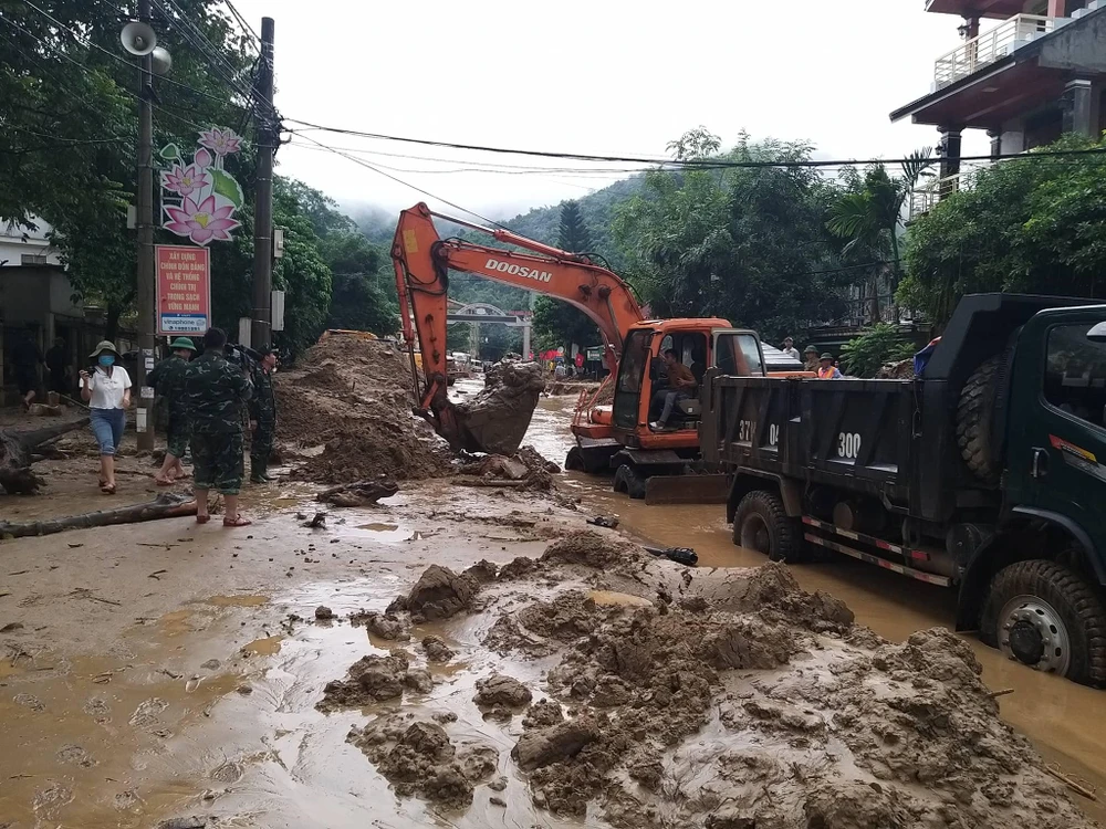 Lực lượng chức năng đào bùn đất trên mặt quốc lộ 7A để thông đường lên Cửa khẩu quốc tế Cầu Treo, sang Lào.