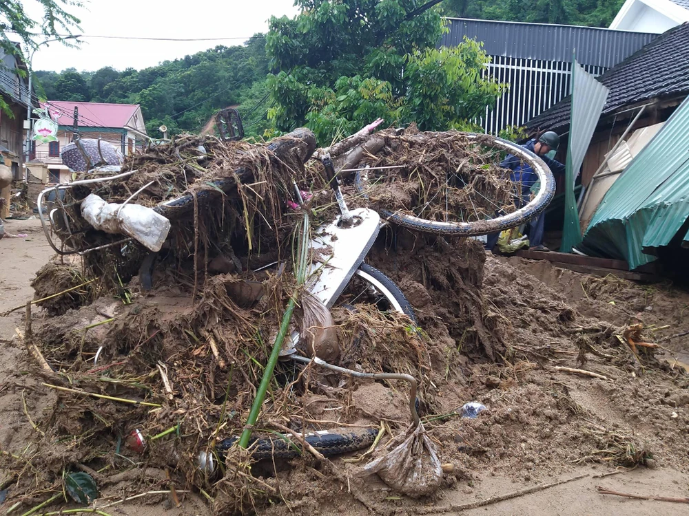 Xe đạp, xe máy của người dân ở thị trấn Mường Xén vùi trong đống đất, rác.