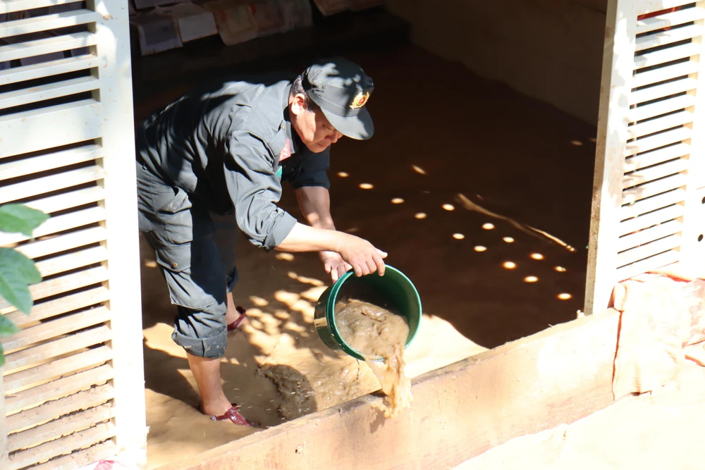 Cảnh sát giúp dân dọn bùn đất.
