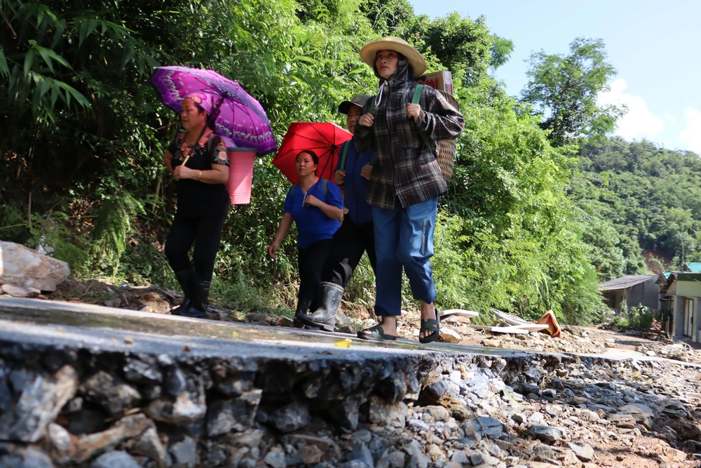 Người dân đi gùi thực phẩm vào tiếp tế cho các gia đình đang bị lũ chia cắt.