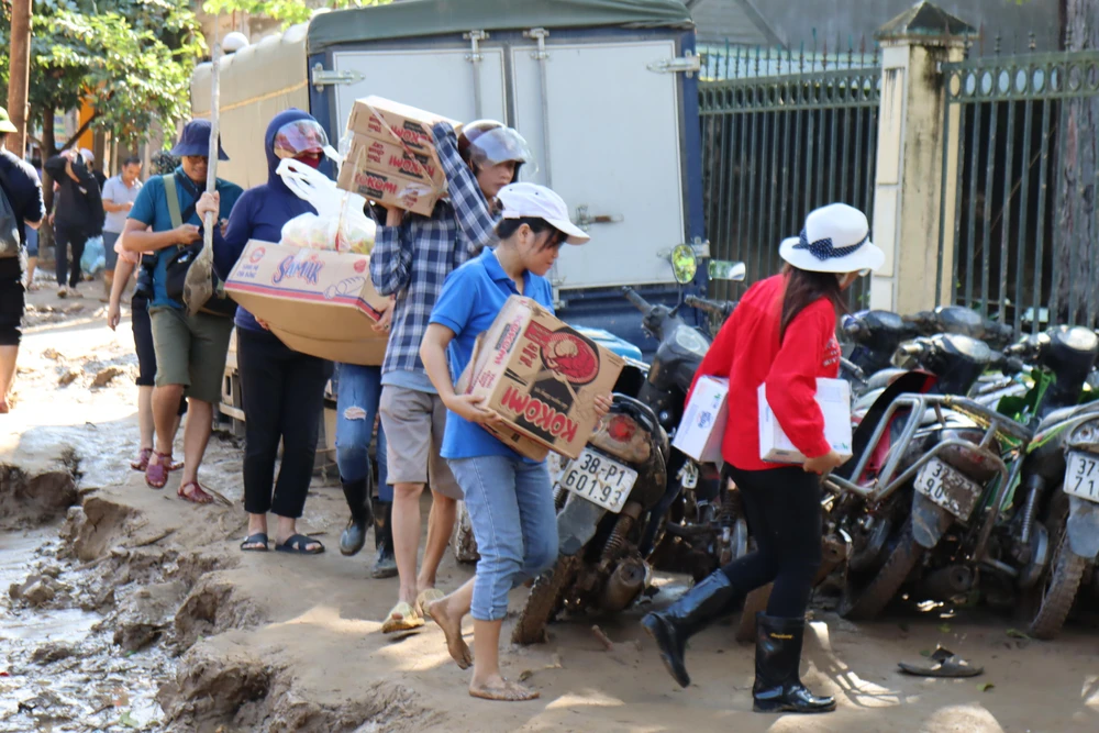 Người dân, đoàn thiện nguyện mang mì tôm vào dân bản xã Tà Cạ.