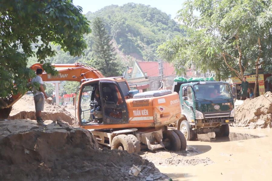 Sau lũ dữ vào sáng 2-10, bùn đất để lại trên mặt đường quốc lộ 7A (đoạn qua thị trấn Mường Xén) cao cả mét, đến nay vẫn chưa thể dọn hết.