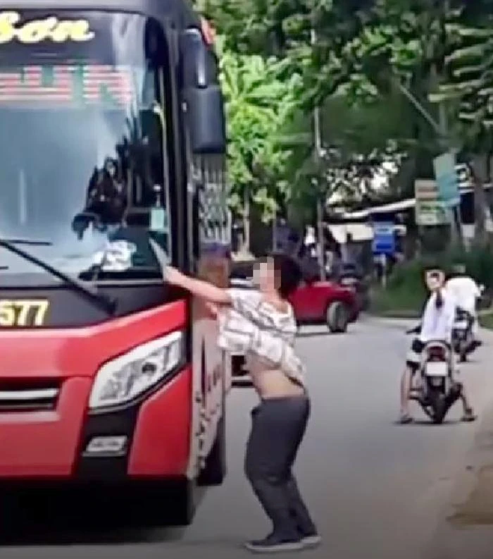 Thanh niên chặn xe khách, chém dao vào thân xe. Ảnh cắt từ video clip.