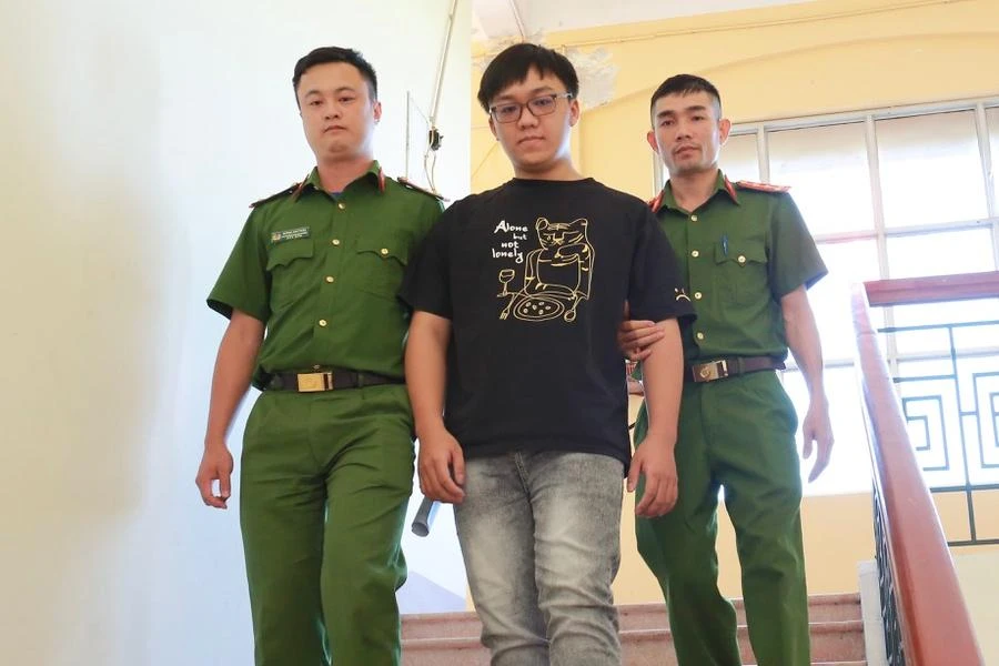 Công an dẫn giải Minh về trại tạm giam. Ảnh: CA.