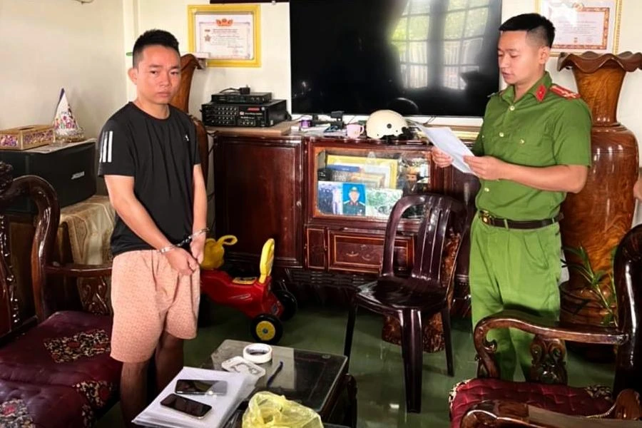 Công an tống đạt quyết định khởi tố bị can, bắt tạm giam bị can. Ảnh: CA.